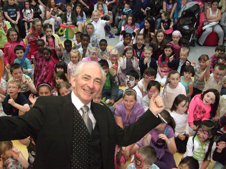 Pat Fallon performing for a large children's party audience